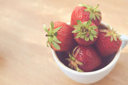 Cup of retro looking vibrant delicious strawberriesの写真素材