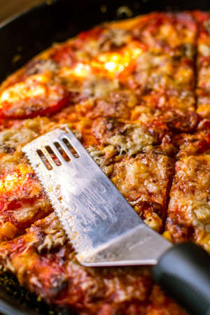 Close-up of home made delicious pizza with cheese, salami and cornの写真素材