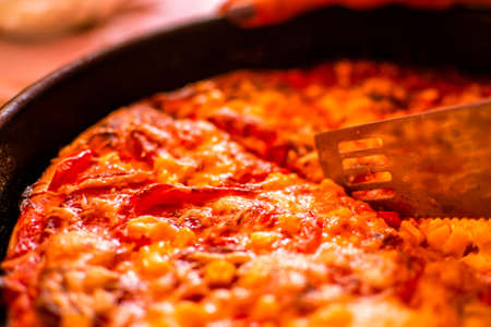 Close-up of home made delicious pizza with cheese, salami and cornの写真素材