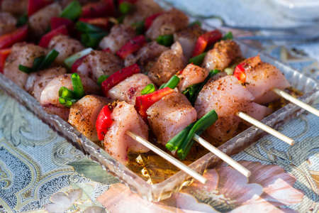 Close up pf delicious chicken breast on wooden skew with fresh vegetables, garlic, paprika fried on mangal barbeque grillの写真素材