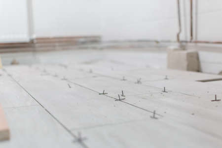 Close up shot of unfinished floor tiles installation in kitchenの写真素材