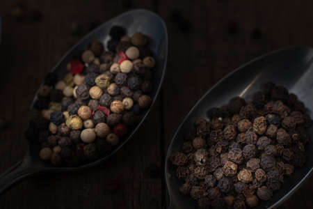 Close-up macro shot of various colored peppercorns layed on a sppon.