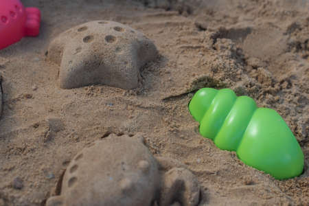 Close up shot of different shapes created in the sand with plastic moldsの写真素材
