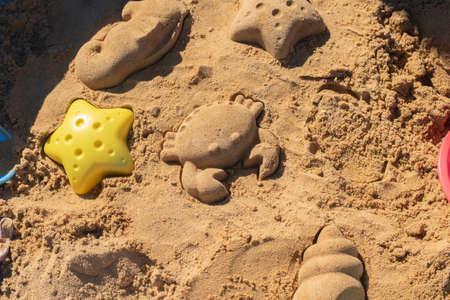 Close up shot of different shapes created in the sand with plastic moldsの写真素材