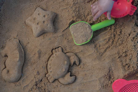 Close up shot of different shapes created in the sand with plastic molds