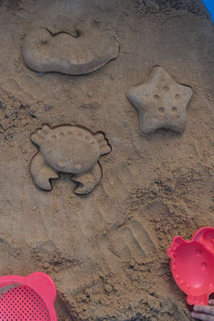 Close up shot of different shapes created in the sand with plastic moldsの写真素材