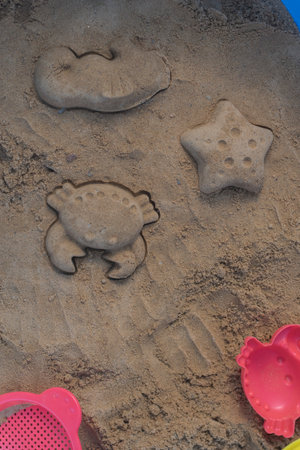 Close up shot of different shapes created in the sand with plastic moldsの写真素材
