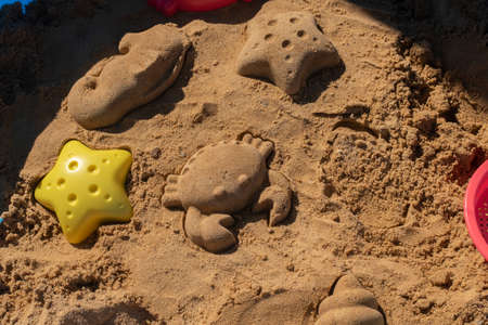 Close up shot of different shapes created in the sand with plastic moldsの写真素材