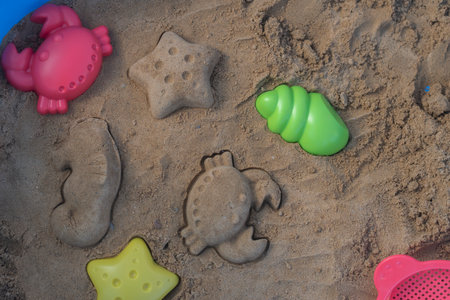 Close up shot of different shapes created in the sand with plastic moldsの写真素材