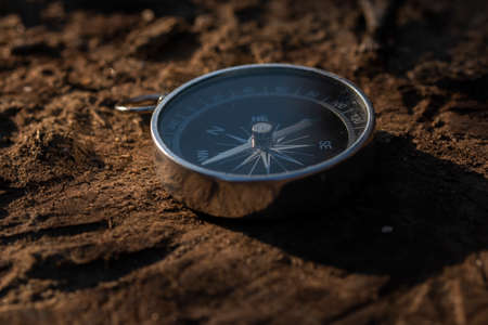 Close up shot of a silver metal compass always pointing it's needle towards North