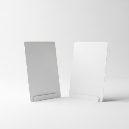 This image features two minimalist tablet holders, one gray and one white, standing upright on a transparent background. The design is sleek and modern, making it ideal for displaying tablets or smartphones. The image is on a transparent background, which allows for versatile use in various design projects.の素材