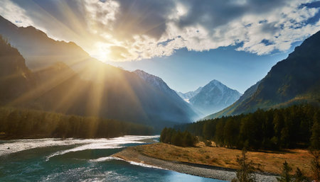 Beautiful mountain landscape with a river in the foreground and the sun shining through the cloudsの素材