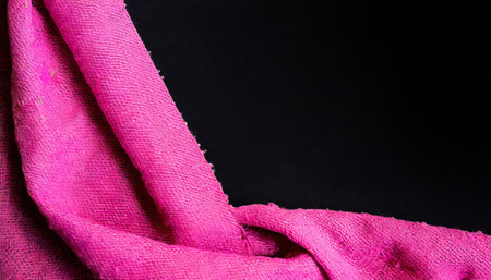 Pink fabric on a black background with space for text or image.の素材