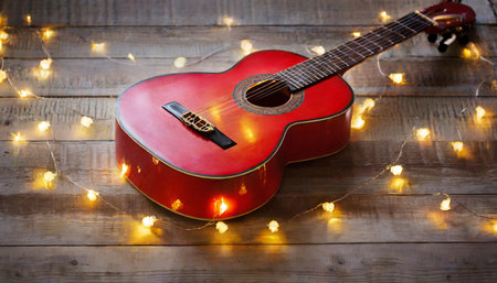 Guitar on wooden background with garland lights. Music conceptの素材
