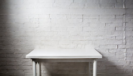 White table on white brick wall background. Minimalism style.の素材