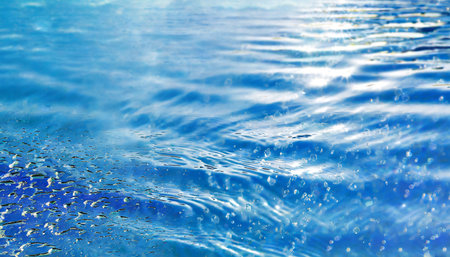 blue water surface with ripples and bubbles of water in the poolの素材