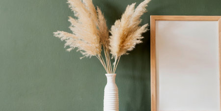 White vase with dry pampas grass on green wall backgroundの素材