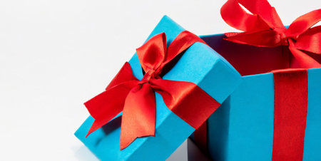 Blue gift box with red ribbon bow isolated on white background. Copy spaceの素材
