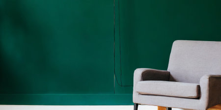 Gray armchair in front of a green chalkboard with copy spaceの素材