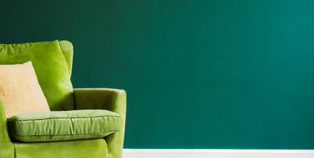 Green armchair with pillows on green wall background, copy spaceの素材
