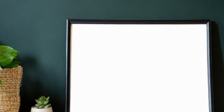 Blank picture frame on green wall background with copy space for text.の素材