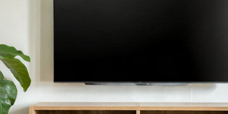 Television screen with blank black screen on wooden cabinet in living roomの素材
