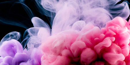 Colorful pink and blue cloud of smoke isolated on black background.の素材