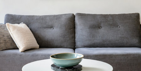 Coffee cup and pillow on sofa in living room, stock photoの素材