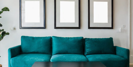 Living room interior with green sofa and blank picture frames on wall.の素材