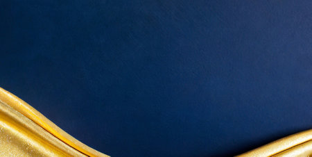 golden fabric on blue background with copy space for text or imageの素材