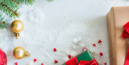 Christmas background with fir branches, gift boxes and decorations on snow.の素材