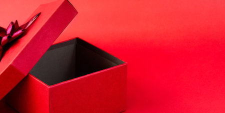 Open red gift box on red background with copy space. Top view.の素材