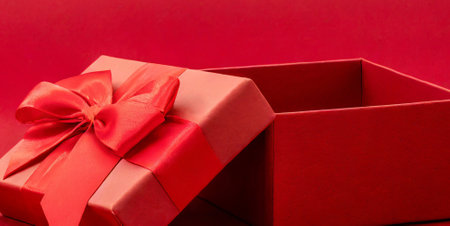 Red gift box with red ribbon on red background, Valentine's day conceptの素材