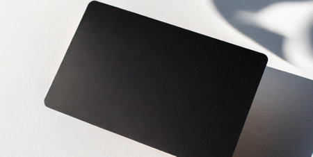 Blank black business card mockup on white background with shadow overlayの素材