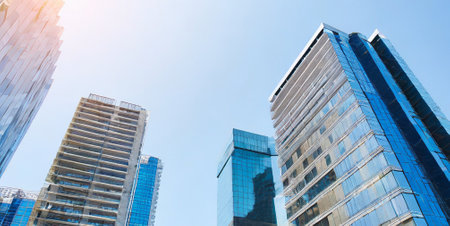 Modern skyscrapers in business district against blue sky, business conceptの素材