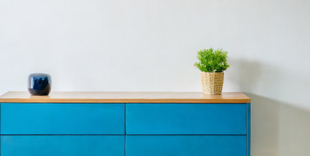 Blue chest of drawers with plant in pot on white wall backgroundの素材