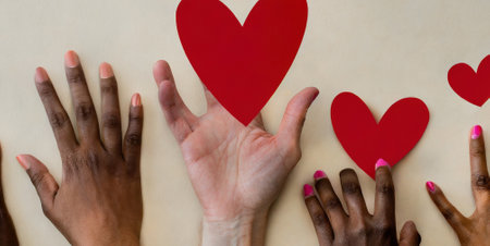 Group of hands holding red hearts against white background with vignetteの素材