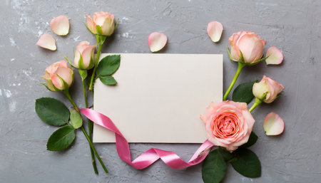 Beautiful pink roses with blank card on grey background, flat layの素材