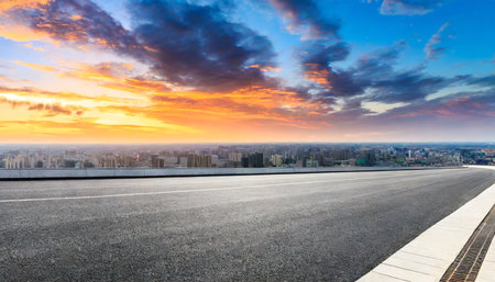 asphalt road and city skyline with colorful sky clouds at sunsetの素材