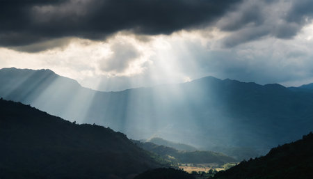 rays of light shining through dark clouds over mountains cinematic sceneの素材