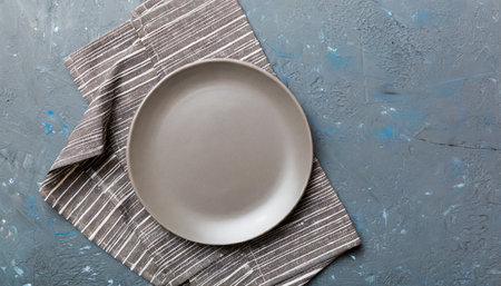 top view on colored background empty round gray plate on tablecloth for food empty dish on napkin with space for your designの素材