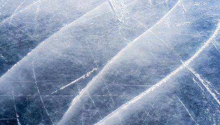 ice background texture and snow surface with marks and lines from skating ice hockey rink arena or stadium from top view light blue frost wallpaper rough frosty traces from winter sport icy lakeの素材
