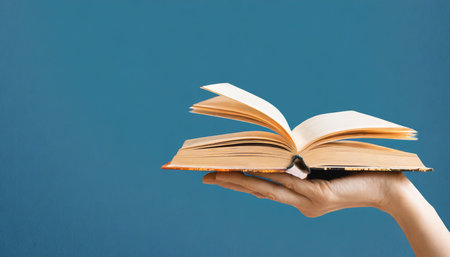 art collage hand with a book on blue background with copy spaceの素材