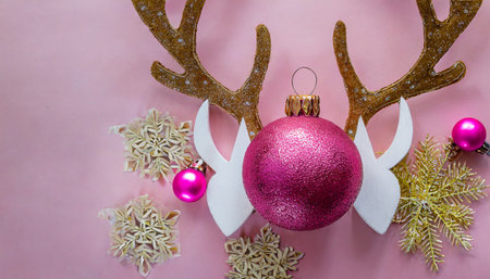 christmas decoration with reindeer horns and pink ball on a pink backgroundの素材