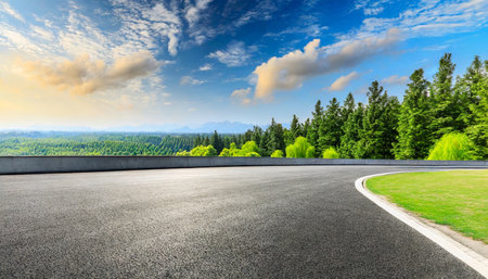 asphalt road and green forest landscape under the blue skyの素材