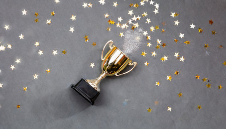 sparkles grey background with a winners cup flat lay styleの素材