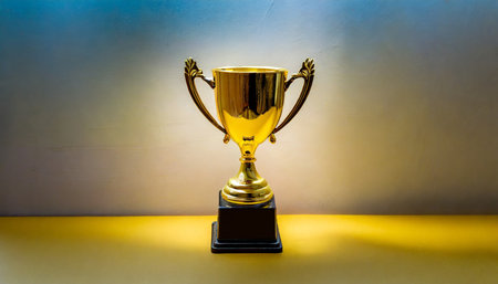 Golden trophy cup on a yellow background. Winner concept. Place for text.の素材