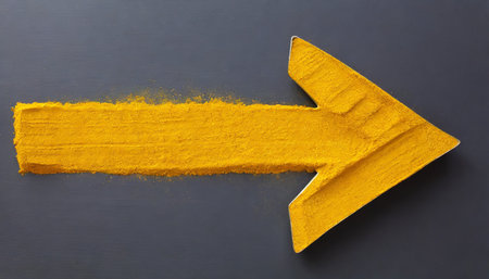 Yellow arrow painted with yellow paint on black background. Concept of direction.の素材