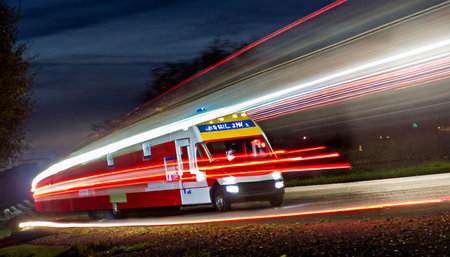 Ambulance car on the road at night with motion blur lightsの素材