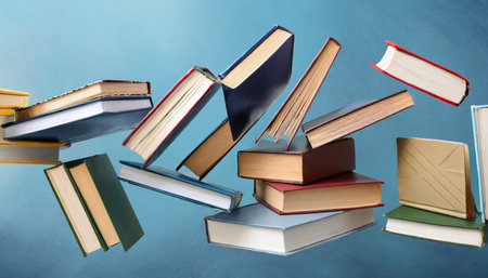 many hardcover books flying on light blue backgroundの素材